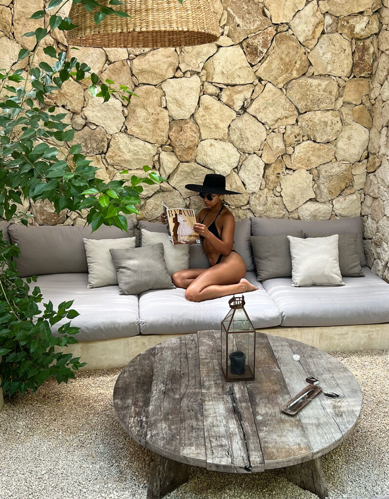 Woman relaxing in the outdoor patio of an Airbnb in Tulum.