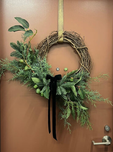 Whimsical Christmas wreath hanging on the door.